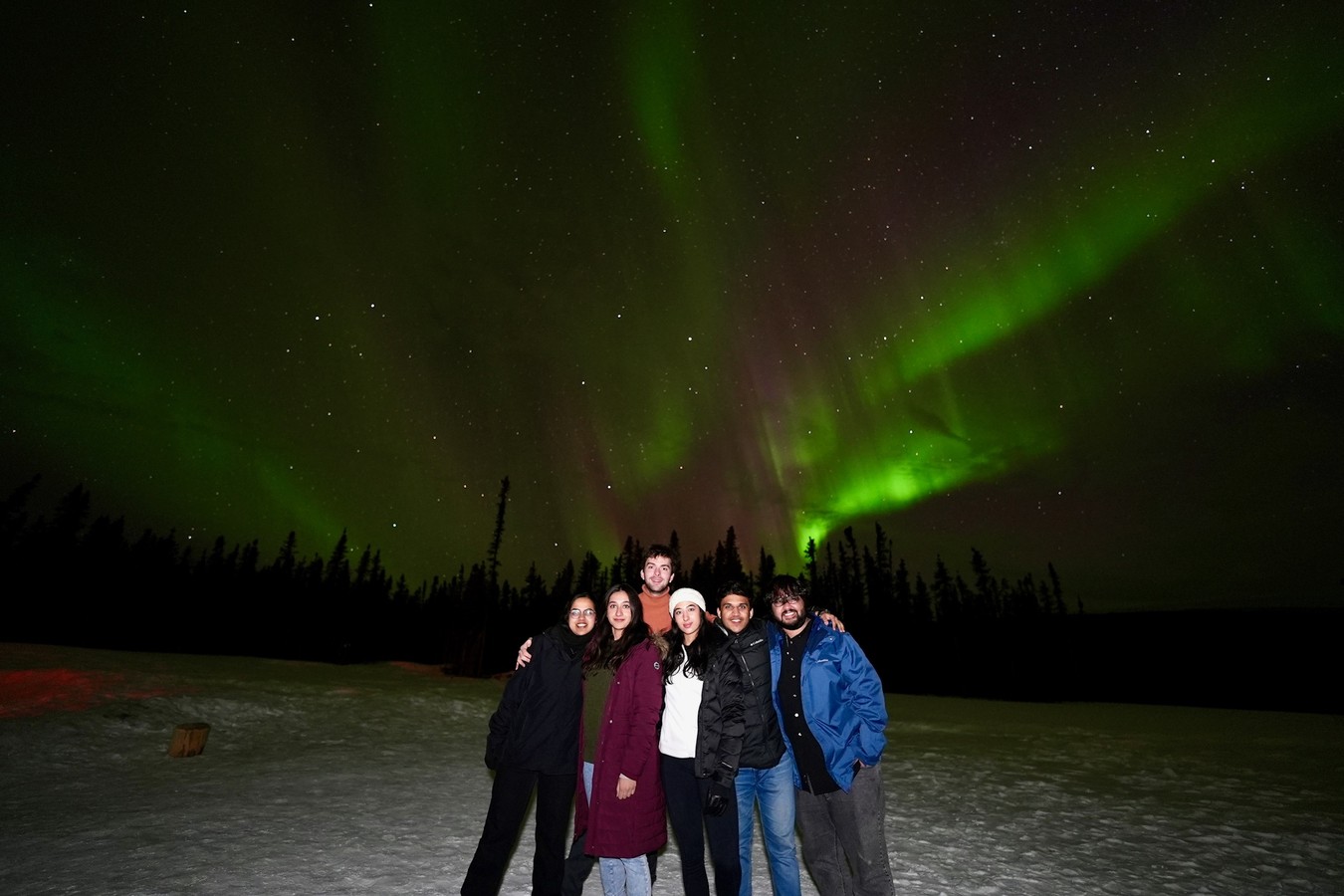 Friends together under the aurora on the Alaska trip